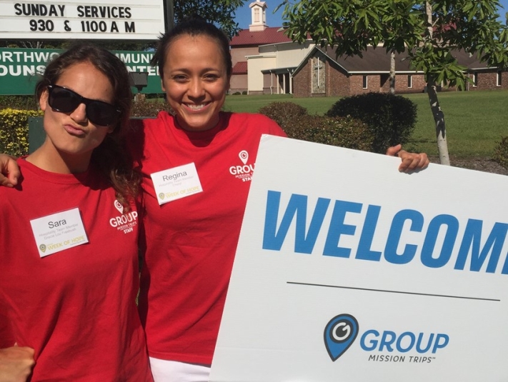 Employees holding welcome sign